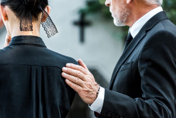 cropped-view-of-man-touching-woman-on-funeral-WXHCDM2-min