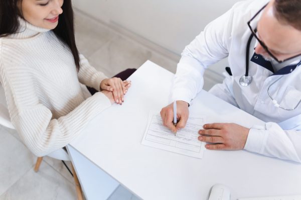 top-view-of-patient-and-doctor-taking-notes-the-p-2022-02-17-19-20-05-utc