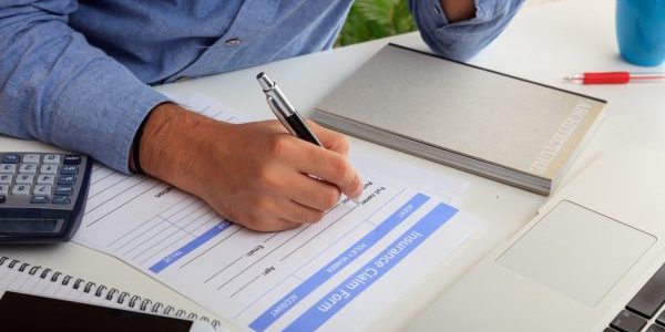 man-preparing-an-insurance-claim-form-2021-08-26-16-34-02-utc (1)